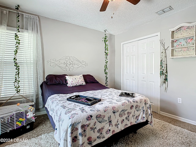 bedroom with carpet flooring, a textured ceiling, ceiling fan, and a closet