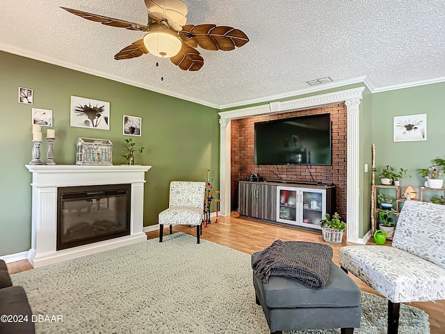 living room featuring ornamental molding, wood-type flooring, and a textured ceiling