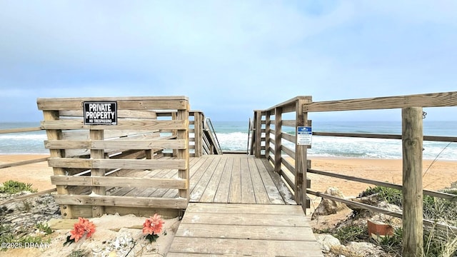 view of home's community with a water view and a beach view