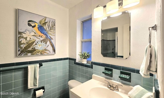 bathroom featuring vanity, tile walls, and toilet