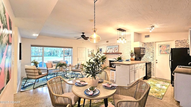 dining area featuring vaulted ceiling, a fireplace, sink, ceiling fan, and a textured ceiling