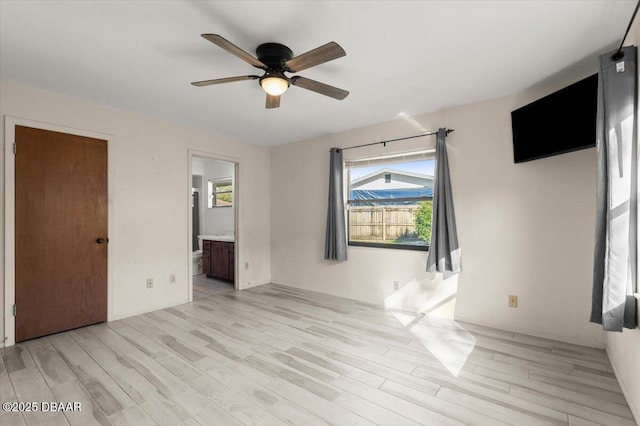 unfurnished bedroom with ceiling fan, ensuite bathroom, and light hardwood / wood-style flooring