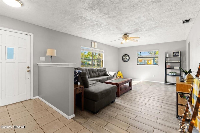 living room featuring ceiling fan, a textured ceiling, and light hardwood / wood-style flooring