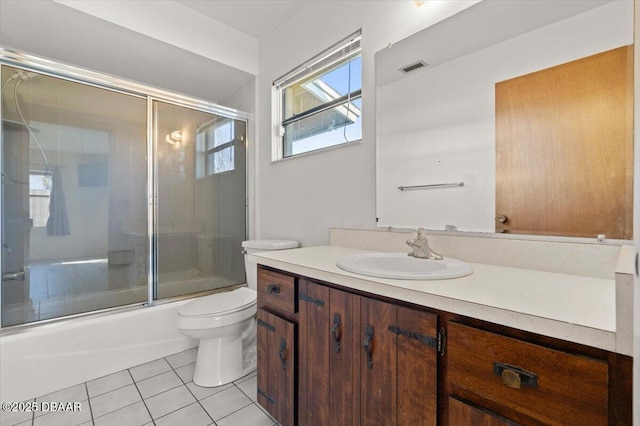 full bathroom with shower / bath combination with glass door, tile patterned floors, toilet, and vanity