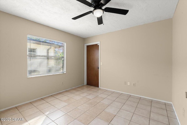 tiled empty room featuring ceiling fan and a textured ceiling