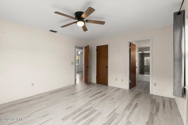 unfurnished bedroom with connected bathroom, light hardwood / wood-style flooring, and ceiling fan