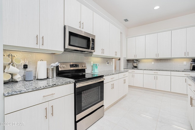 kitchen featuring tasteful backsplash, light stone countertops, stainless steel appliances, and white cabinets