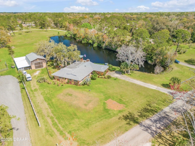 drone / aerial view featuring a forest view and a water view