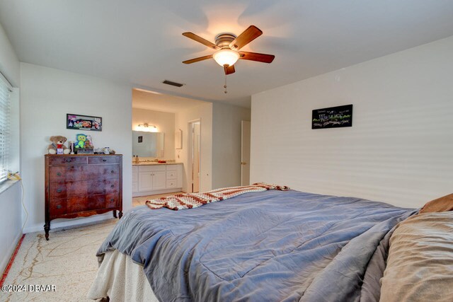 bedroom with light carpet, ceiling fan, and connected bathroom