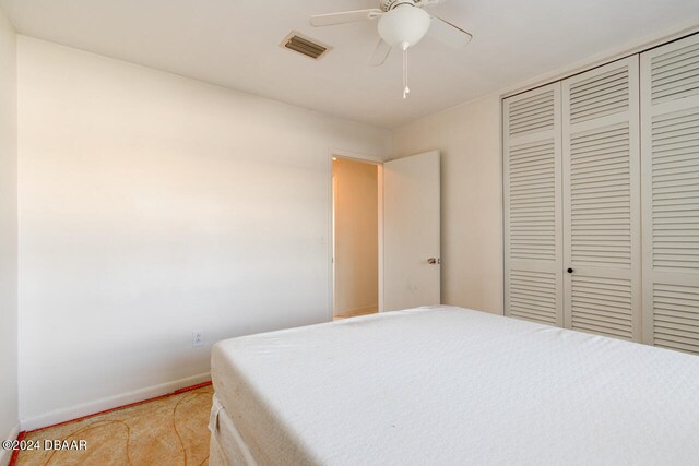 carpeted bedroom with a closet and ceiling fan