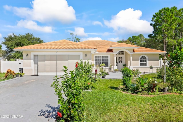 mediterranean / spanish-style home with a garage and a front yard