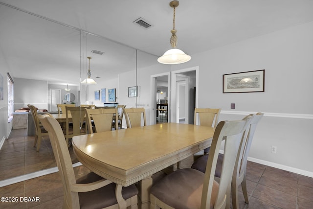 dining space featuring dark tile patterned floors