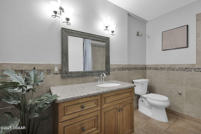 bathroom featuring tile patterned flooring, vanity, tile walls, and toilet