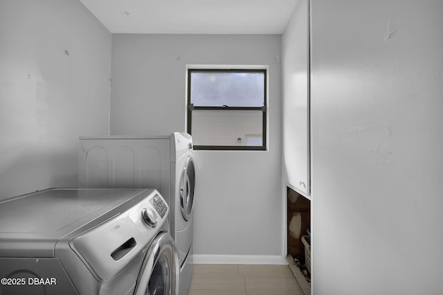 laundry area featuring washer and clothes dryer and cabinets