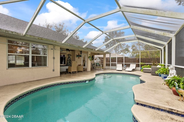 view of swimming pool featuring outdoor lounge area, a patio area, and a lanai