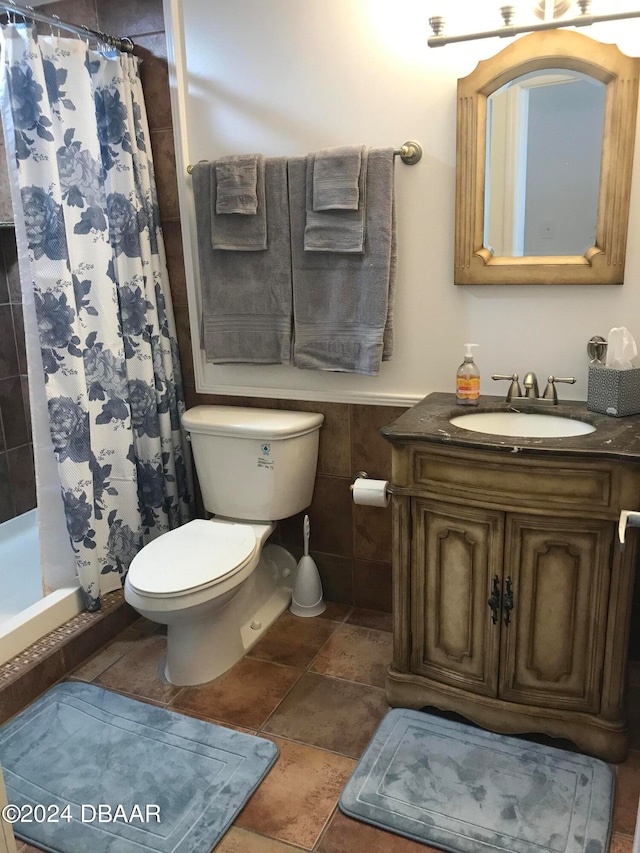 bathroom featuring tile walls, vanity, curtained shower, and toilet