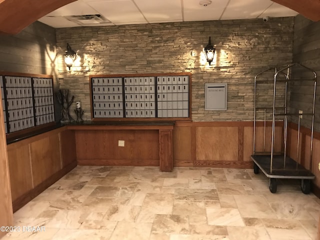 3501 S Atlantic Ave Unit 2050, Daytona Beach, FL 32118 - wine room featuring mail area, wooden walls, and light stone finish floors