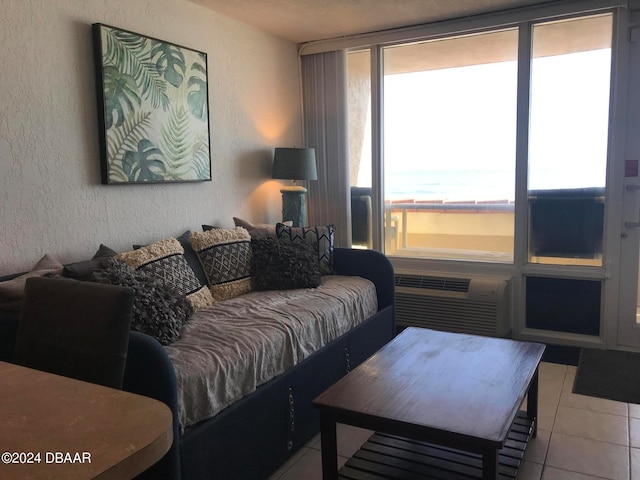 living room featuring an AC wall unit, a wealth of natural light, and light tile patterned floors