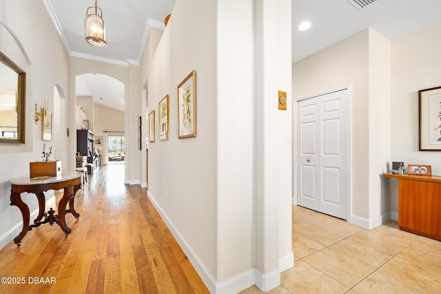 hallway featuring ornamental molding, light hardwood / wood-style flooring, and an inviting chandelier