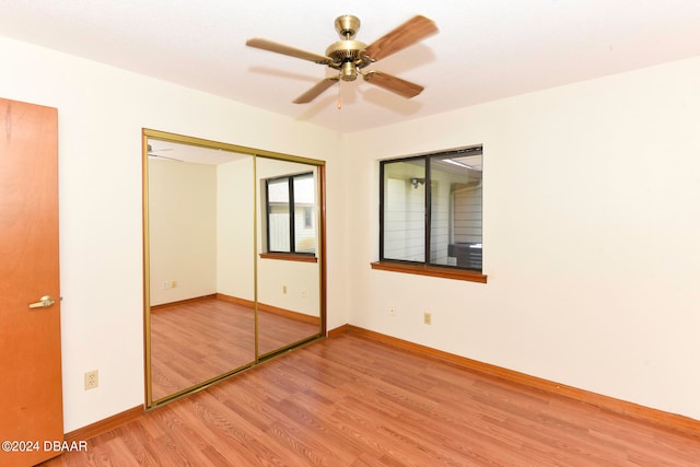 unfurnished bedroom featuring light hardwood / wood-style flooring, ceiling fan, and a closet