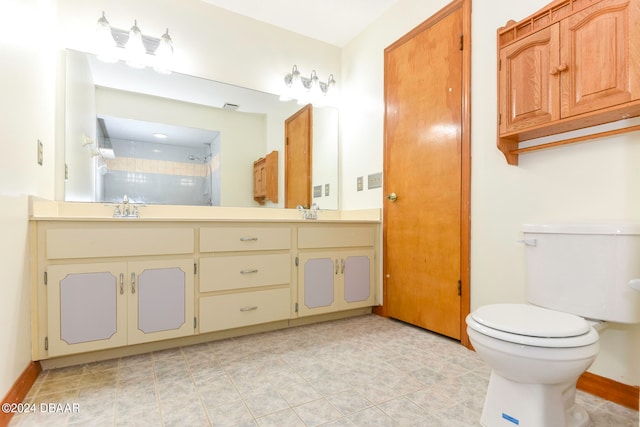 bathroom featuring tile patterned floors, vanity, toilet, and tiled shower