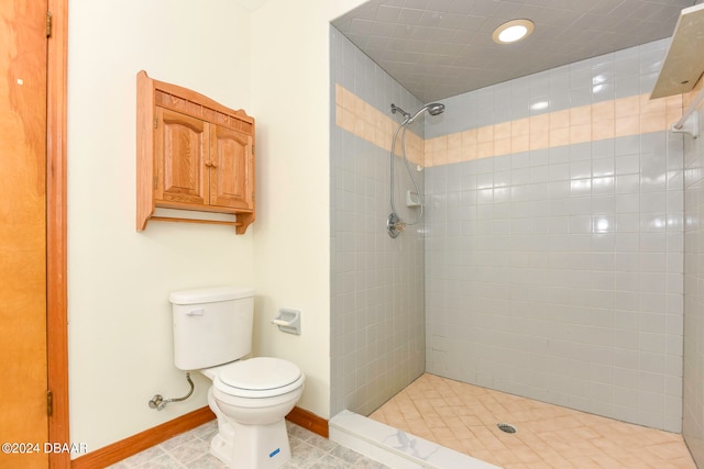 bathroom featuring tile patterned floors, toilet, and tiled shower