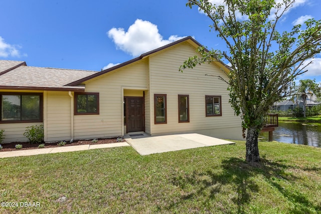 ranch-style house with a front lawn and a patio area