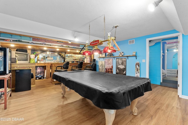 rec room with visible vents, pool table, bar area, and wood finished floors