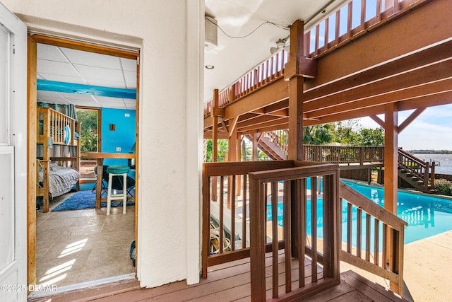 wooden deck featuring an outdoor pool and stairs