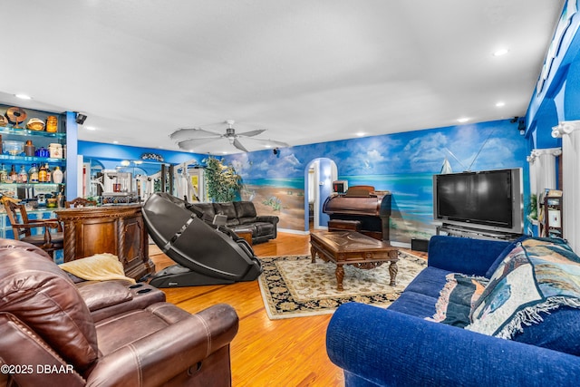 living room with ceiling fan, wood-type flooring, and indoor bar