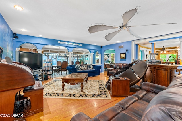 living room with ceiling fan, plenty of natural light, and light hardwood / wood-style floors