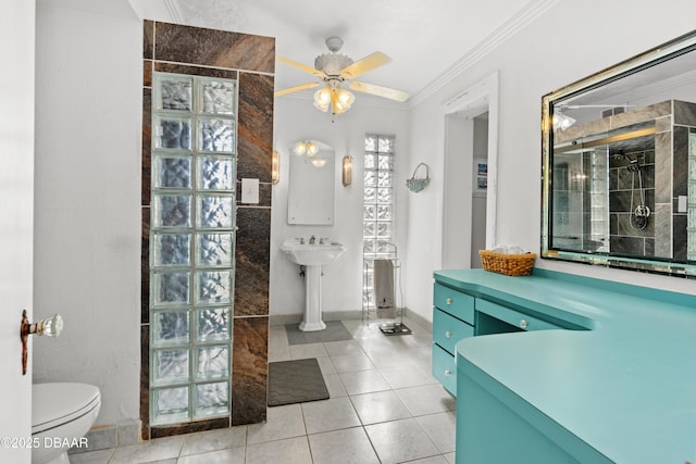 full bath with a tile shower, ceiling fan, tile patterned flooring, crown molding, and toilet