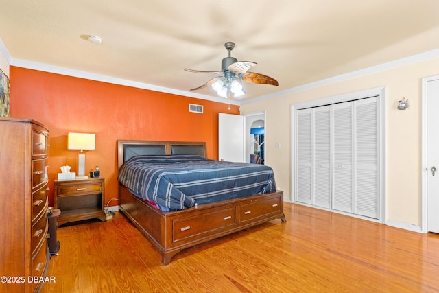 bedroom with ornamental molding, wood-type flooring, and ceiling fan