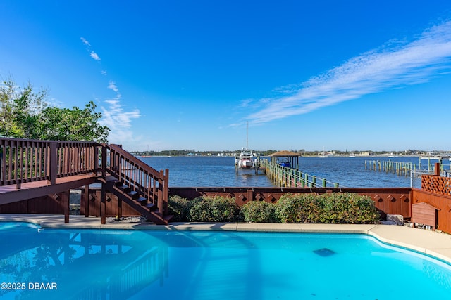 view of pool featuring a boat dock and a water view