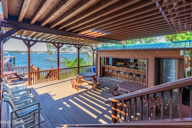 wooden terrace featuring a dock, a water view, and outdoor dry bar