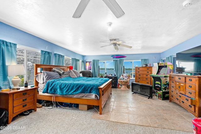 bedroom with ceiling fan and a textured ceiling