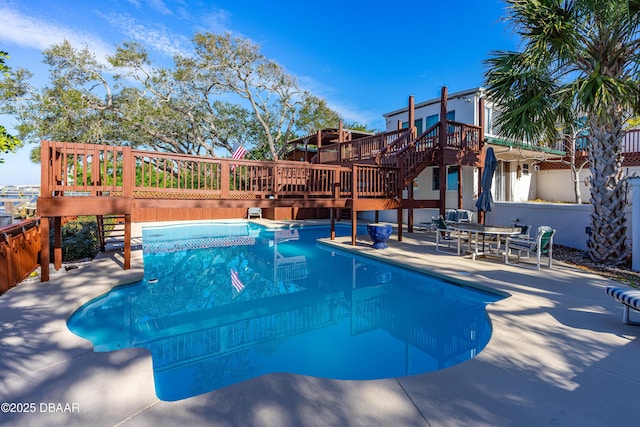 view of swimming pool featuring a wooden deck and a patio area