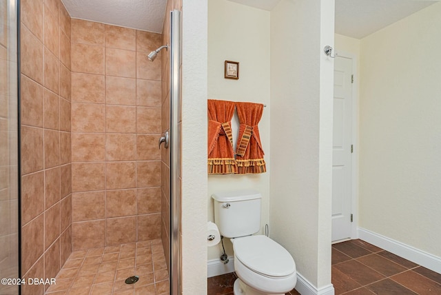 bathroom featuring tile patterned floors, toilet, walk in shower, and a textured ceiling