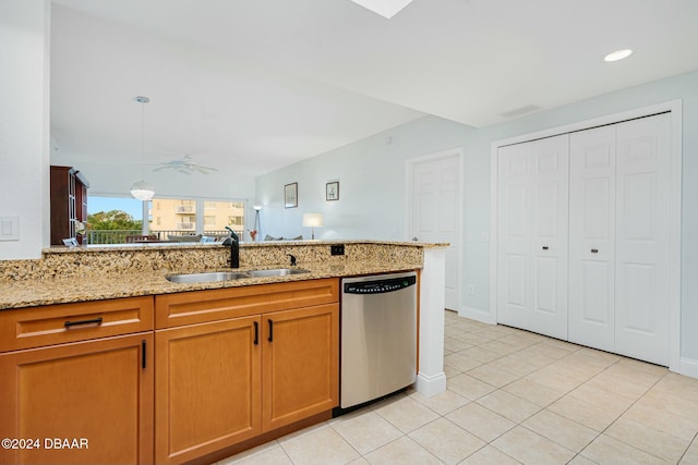 kitchen with light stone counters, stainless steel dishwasher, ceiling fan, and sink