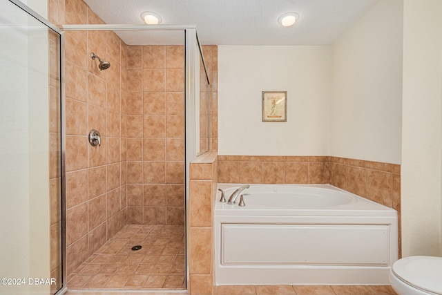 bathroom with shower with separate bathtub, tile patterned flooring, a textured ceiling, and toilet