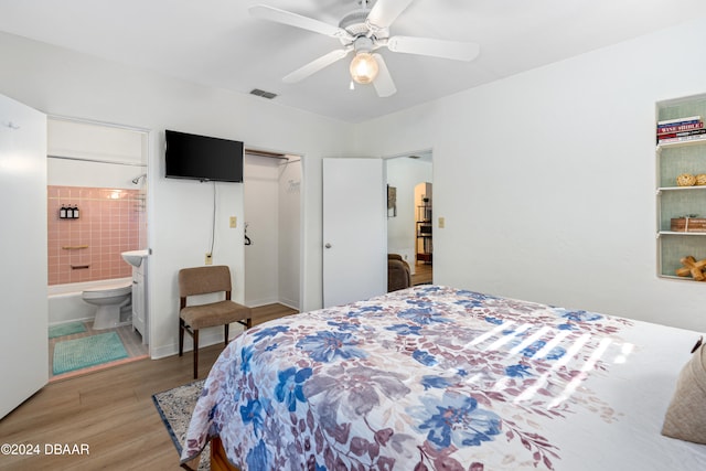 bedroom with ensuite bathroom, ceiling fan, and hardwood / wood-style flooring