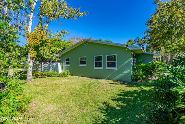 view of side of home with a yard