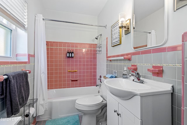 full bathroom featuring vanity, toilet, shower / bath combo with shower curtain, and tile walls