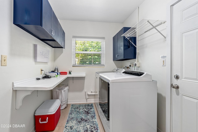 clothes washing area featuring cabinets, separate washer and dryer, and light hardwood / wood-style floors