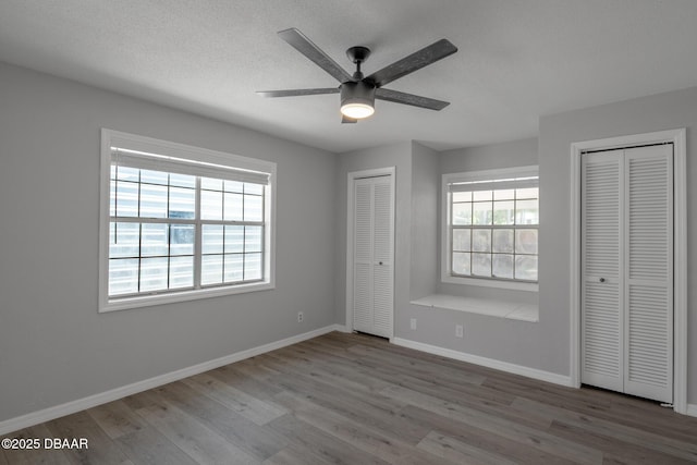 131 Lake Charles Rd, Deland, FL 32724 - unfurnished bedroom with two closets, wood finished floors, baseboards, a textured ceiling, and ceiling fan