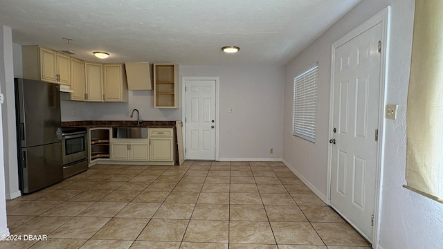 kitchen featuring light tile patterned floors, sink, black fridge, stainless steel electric stove, and cream cabinetry