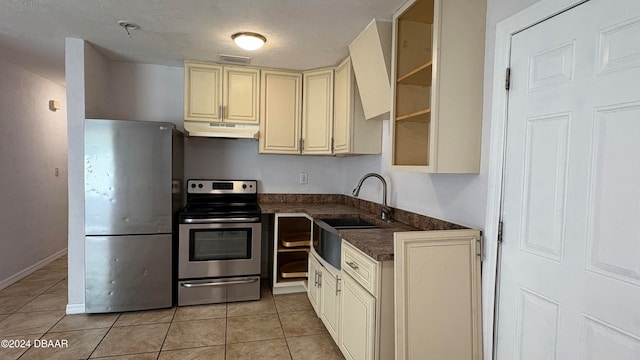 kitchen featuring cream cabinets, light tile patterned flooring, sink, and appliances with stainless steel finishes