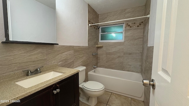 full bathroom featuring tile patterned floors, toilet, tile walls, vanity, and tiled shower / bath combo