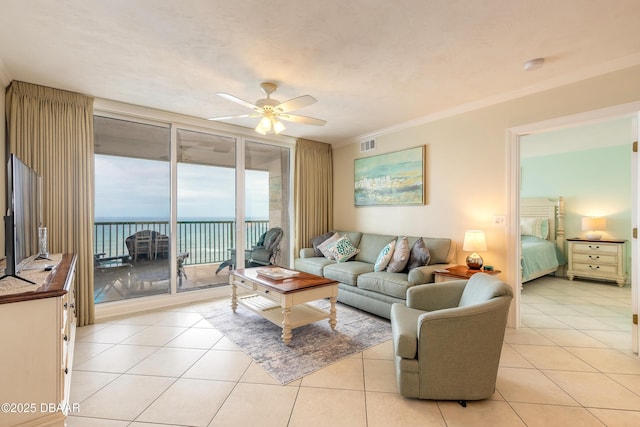 tiled living room with ornamental molding, expansive windows, ceiling fan, and a water view