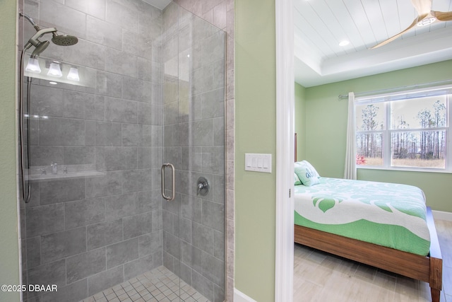 bathroom with a tray ceiling and an enclosed shower